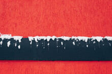 The Wall Texture Is Red With A Black Band Covered In Snow. Background Flag Concept.
