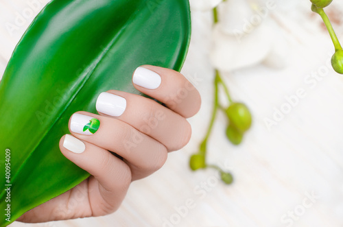 Foto Female hand with white nail design