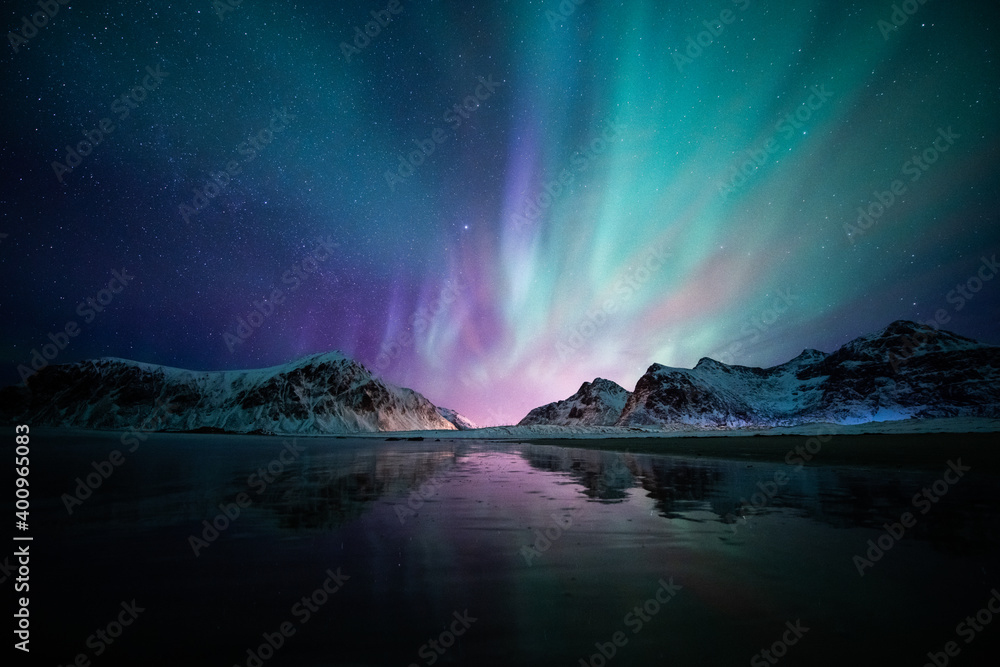Aurora borealis on the Beach in Lofoten islands, Norway. Green northern lights above mountains. Night sky with polar lights. Night winter landscape. - obrazy, fototapety, plakaty 