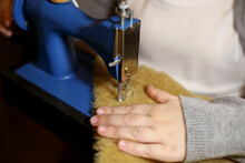 A Girl Sews A Teddy Bear On A Sewing Machine