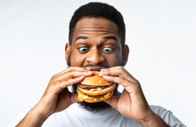 Funny Hungry African Guy Eating Burger Standing On White Background