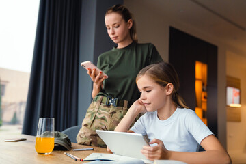 Wall Mural - Beautiful mother and daughter using tablet computer and cellphone