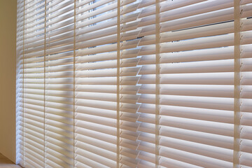 Leinwandbilder - Wood blinds closeup in the interior. Automatic venetian blinds beige color on large windows. Wooden slats 50mm wide. Wood floor, beige walls.