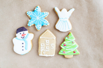 Wall Mural - Gingerbread painted colored gingerbread cookies and spices and snowflakes on a craft background close-up. Christmas celebration concept. New Year's food.