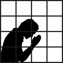 Silhouette of man praying in prison closeup