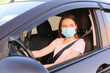 © Pixel-Shot - Beautiful woman wearing medical mask in modern car