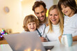 © pikselstock - Happy young family using laptop at home