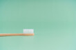 Environmentally friendly bamboo wood antibacterial toothbrush on light green background