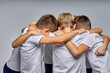© Roman - rear view on boys soccer team hugging, preparing for competitions, sharing advice each other. gathered to play football, soccer. isolated