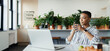 © Paul Bradbury/Caia Image - Young businesswoman with coffee working at laptop in office