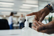 © Paul Bradbury/Caia Image - Close up businessman using hand sanitizer pump in office