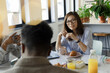 © Paul Bradbury/Caia Image - Business people talking over breakfast in office meeting
