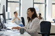 © Paul Bradbury/Caia Image - Businesswoman working at computer in open plan office