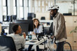 © Paul Bradbury/Caia Image - Businessman with bicycle talking to businesswomen in office