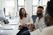 © Paul Bradbury/Caia Image - Business people in face masks talking in office meeting