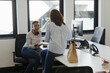 © Paul Bradbury/Caia Image - Businesswomen eating takeout lunch at desk in office