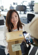 © Paul Bradbury/Caia Image - Businesswoman receiving packages from courier in office