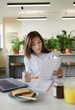 © Paul Bradbury/Caia Image - Businesswoman reviewing paperwork in office lounge