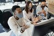 © Paul Bradbury/Caia Image - Business people in face masks video conferencing at computer