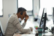 © Paul Bradbury/Caia Image - Tired businesswoman with head in hands at computer desk
