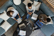 © Paul Bradbury/Caia Image - Business people with laptops and paperwork meeting on office sofa