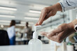 © Paul Bradbury/Caia Image - Close up businesswoman using hand sanitizer dispenser