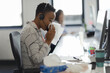 © Paul Bradbury/Caia Image - Businesswoman in headset blowing nose into tissue at office desk