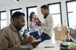 © Paul Bradbury/Caia Image - Business people eating takeout lunch at desk in office