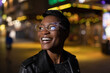 © Tom Merton/Caia Image - Happy young woman in funky glasses on city street at night