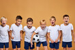 © Roman - kids soccer players celebrate a winning in school sports tournament, studio portrait of happy joyful kids in uniform engaged in football