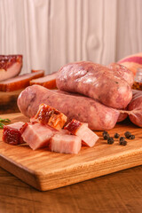 Sticker - Raw brazilian bacon sausages on the wooden board with fresh cubes of bacon and spices - Linguiça de bacon