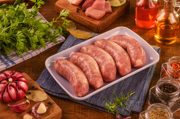 Wall Mural - Brazilian pork leg sausage on white plate with spices and ingredients - Linguiça de pernil