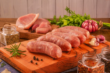 Canvas Print - Brazilian pork leg sausage on wood cutting board with spices and ingredients - Linguiça de pernil