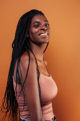 pretty young african american woman posing cheerful gesturing on brown background, lifestyle people concept