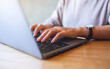 © Farknot Architect - Closeup image of a woman working and typing on laptop computer keyboard on wooden table