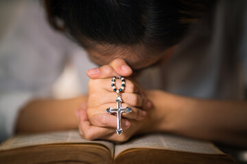 osary of jesus cross in hands of woman praying for god blessing