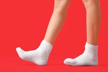 Legs of young woman in socks on color background