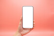 © BoszyArtis - Hand woman holding mobile smartphone with blank screen isolated on pink background, close-up hand touching phone isolated on pink,mock-up smartphone blank screen easy adjustment .