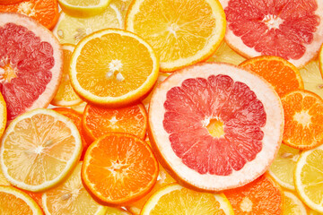 Wall Mural - Colorful creative background of orange, lemon, grapefruit and Mandarin slices. Flat lay macro close-up, top view