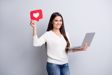 Sticker - portrait of attractive cheerful girl holding in hands using laptop paper like card isolated over gre