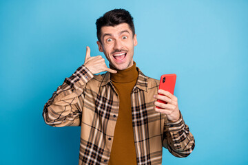 Poster - Photo of young happy excited smiling crazy cheerful man hold smartphone ask to call isolated on blue color background