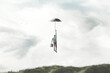 illustration of man flying in the sky with umbrella, surreal freedom concept