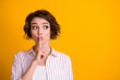 Photo of surprised girl look copyspace confidential information put index finger lips keep quiet wear striped shirt isolated over bright shine color background