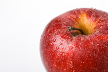 Water drop on red apple over white background