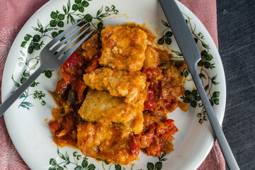 Wall Mural - Cod with red peppers, tomato and onion with knife and fork