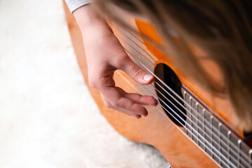 Close up of hand playing acoustic guitar. Practicing classic musical instrument. Home school education