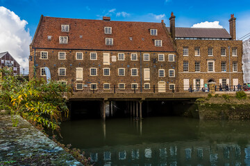 Sticker - A view towards the eighteen century, Three Mills complex showing the waterway under the mills in Lee Valley, London in the summertime