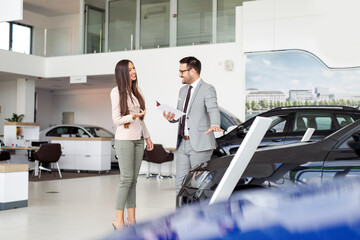 Wall Mural - Salesperson selling cars at car dealership.