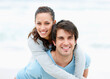 © momentimages/Tetra Images - Man giving woman a piggy back ride
