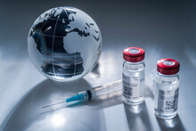 Glass Globe And Syringe With Vaccine On Gray Background